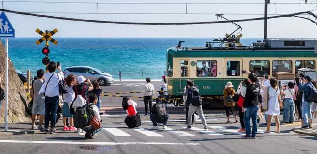 turisti passaggio a livello treno Enoshima